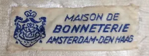 Label met tekst Maison de / Bonneterie / Amsterdam - Den Haag