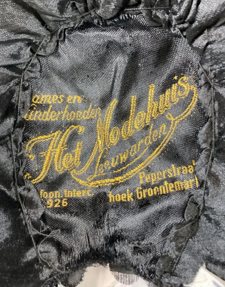 Etiquette avec texte Dames en Kinderhoeden / Het Modehuis Leeuwarden / telefoon.inter. 962 / Peperstraat hoek Groentemarkt