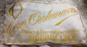 Label met tekst Oerlemans / Dames & Heerkenkleermaker / Dordrecht