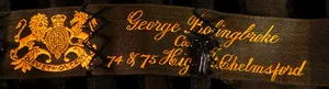 Label met tekst George Bolingbroke / Costumier / 74 & 75 Highstreet Chelmsford