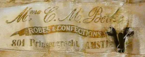 Label met tekst Mme C.M. Berke / ROBES ET CONFECTIONS / 801 Prinsengracht AMSTERDAM