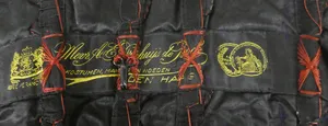 Label met tekst Mevr. A.E. Driehuijs de Bock / Kostumen, mantels en hoeden / Hofleverancier / Den Haag