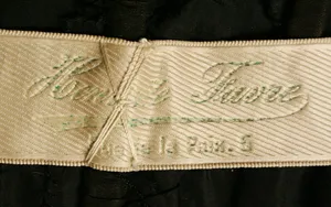 Label met tekst Henriette Favre / Rue de la Paix 6