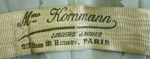 Label met tekst Mme Kornmann / LINGERIE et ROBES / 217 Rue St. Honoré, PARIS