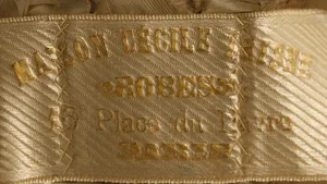 Label met tekst Maison Cécile Laisne / ROBES / 16 Place du Havre / PARIS
