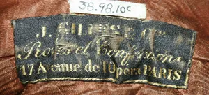 Label met tekst I Gilles et Cie / Robes et Confections / 47 Avenue de L'Opera, Paris