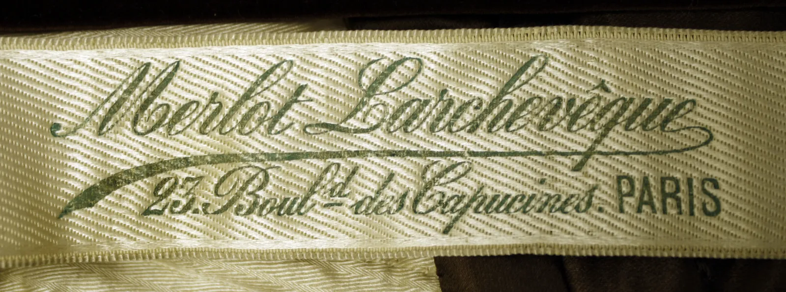 Etiquette avec texte Merlot Larcheveque /  23 Bould. des Capucines, Paris.