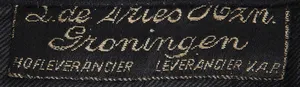 Label met tekst L. de Vries Hzn. / Groningen / Hofleverancier / Leverancier V.A.P.