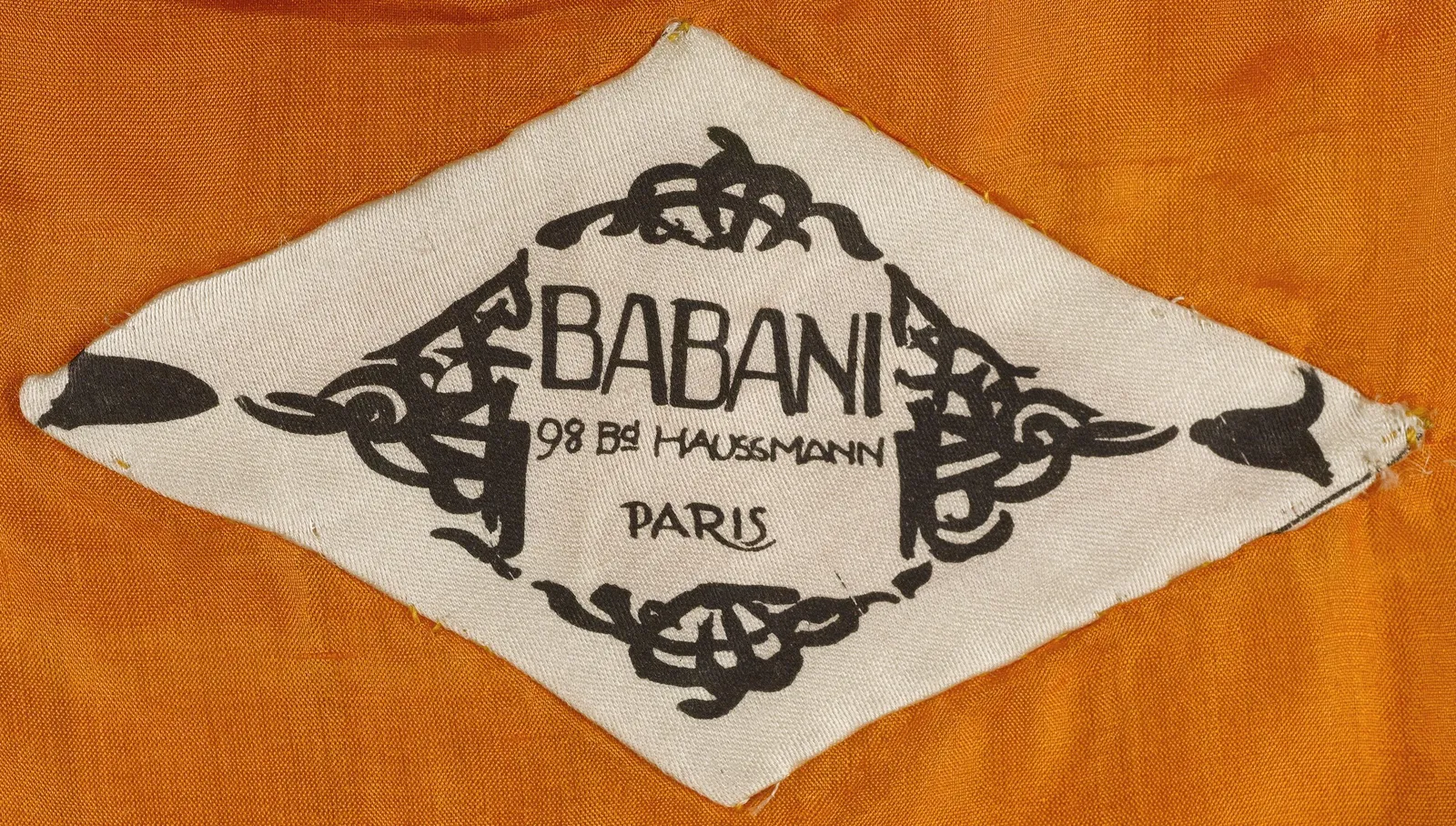Label met tekst BABANI / 98 Bd HAUSSMANN / PARIS