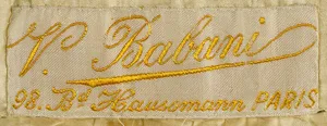 Label met tekst V. Babani / 98. Bd Haussmann PARIS