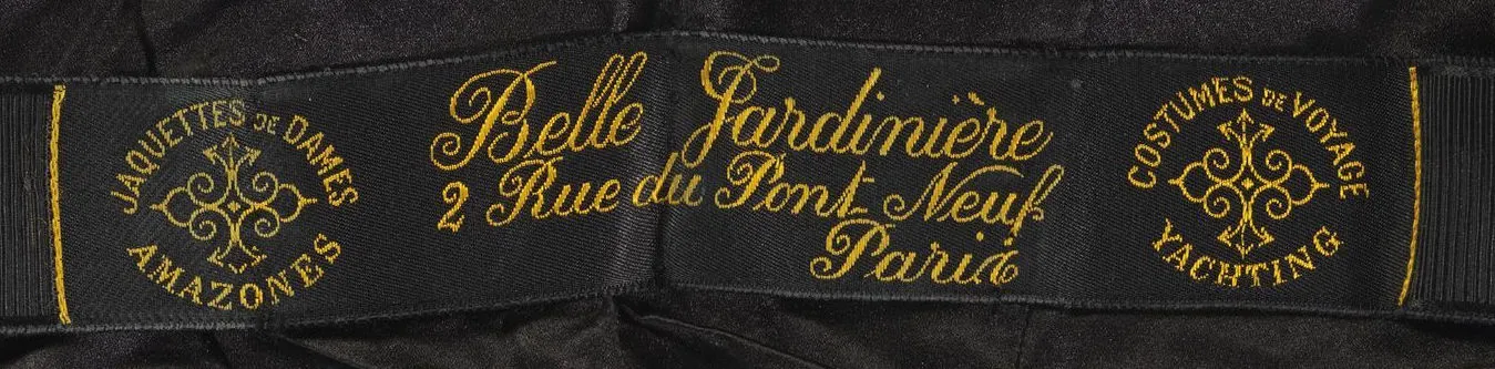 Etiquette avec texte COSTUMES DE VOYAGE YATCHING [ A gauche en rond ] / Belle Jardinière 2, rue du Pont Neuf Paris / JAQUETTE DE DAMES AMAZONES [ A droite en rond et dessin ornemental au milieu ]