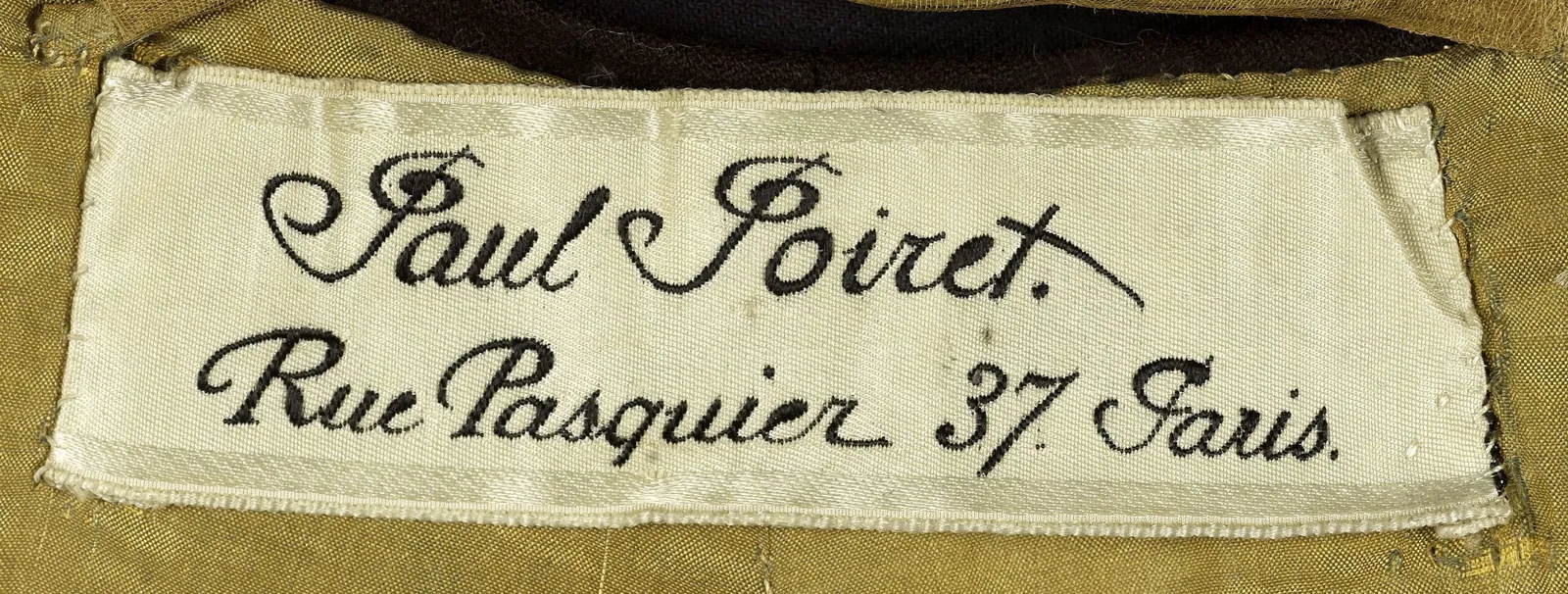 Etiquette avec texte Paul Poiret. Rue Pasquier 37 Paris