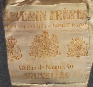 Label met tekst SEVERIN FRERES Fournisseurs de la Famille Royale 40, rue de Namur, 40 BRUXELLES